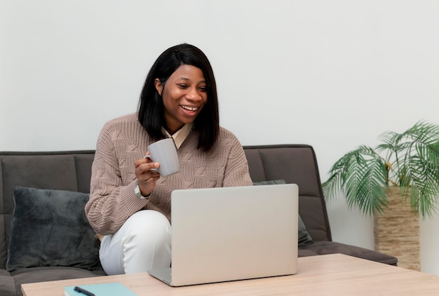 Smiley businesswoman travaillant sur un ordinateur portable à la maison