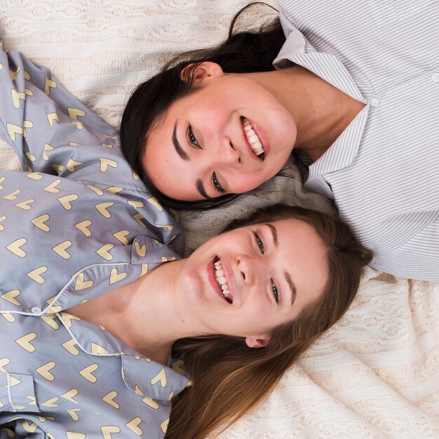 Smiley copines assis couché dans le lit