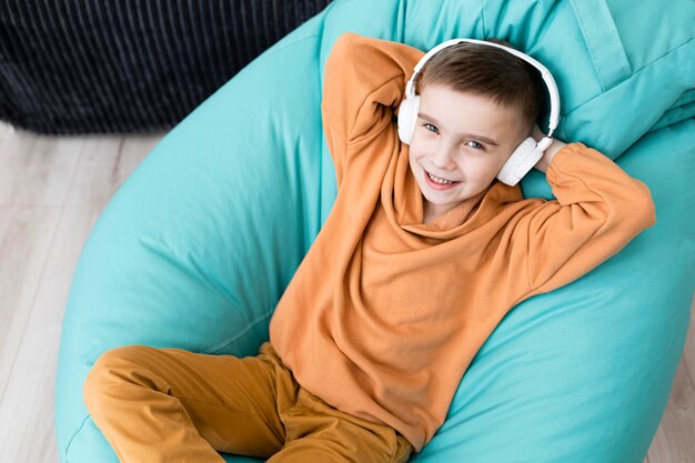 Smiley coup moyen enfant assis sur une chaise de sac de haricots