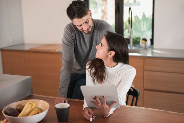 Smiley couple à la maison dans la cuisine