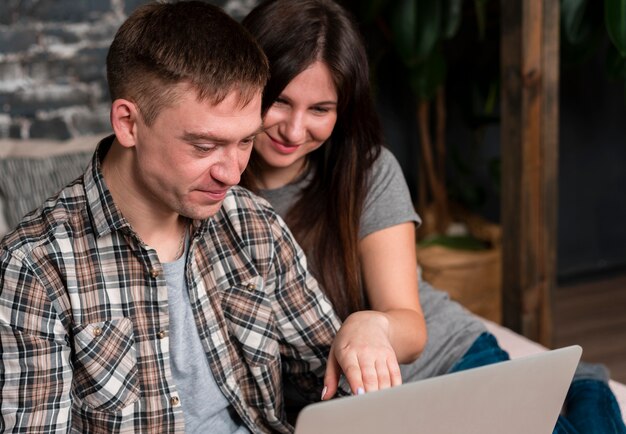 Smiley couple regardant un ordinateur portable