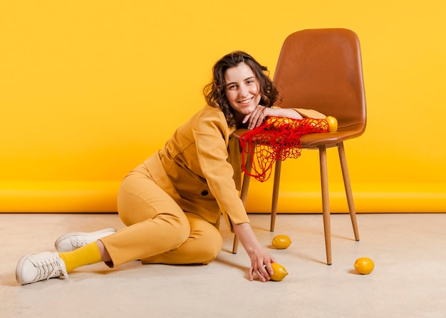 Smiley femelle avec des citrons sur une chaise