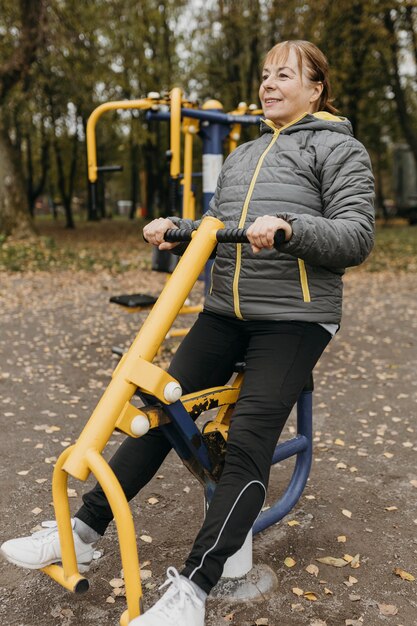 Smiley femme âgée travaillant avec des équipements à l'extérieur