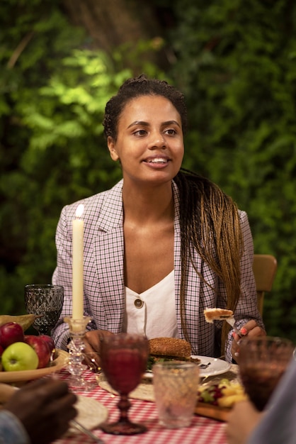 Smiley femme assise à table vue de face