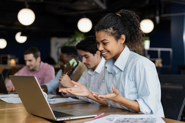 Smiley femme ayant un appel vidéo au bureau