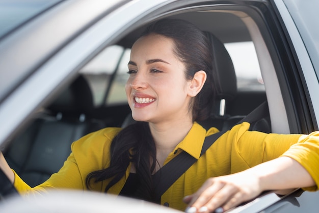 Smiley femme ayant sa ceinture de sécurité sur