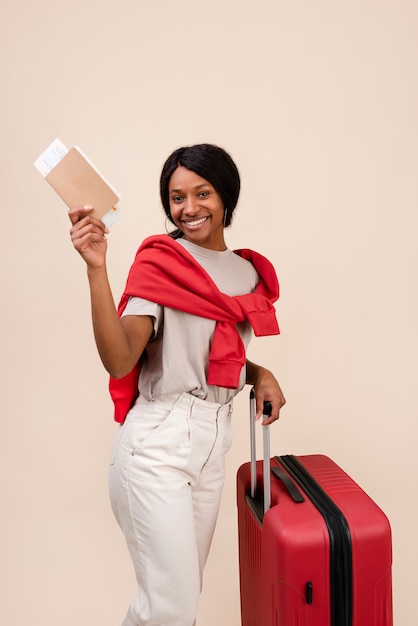 Photo gratuite smiley femme avec un bagage rouge coup moyen