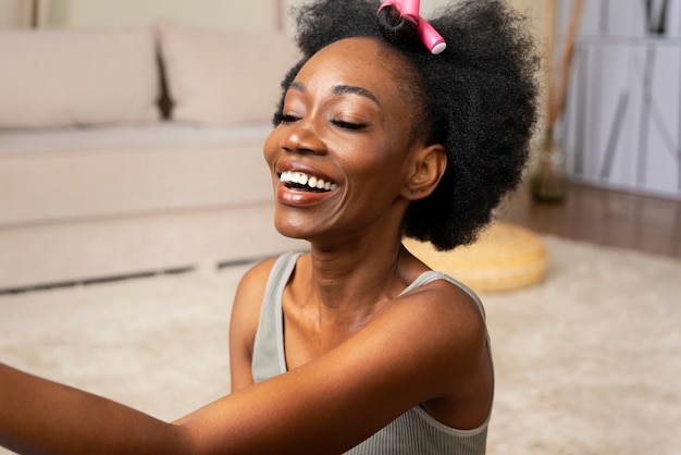 Smiley femme coiffant les cheveux afro vue de côté