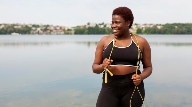 Smiley femme à l'extérieur prendre une pause de la corde à sauter