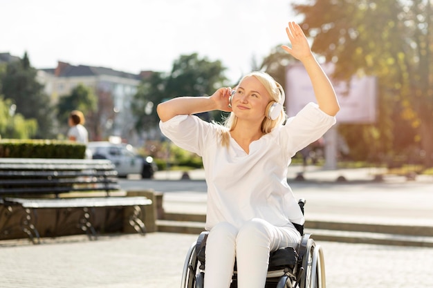 Smiley femme en fauteuil roulant, profiter de la musique sur les écouteurs