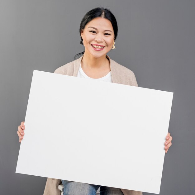 Smiley femme avec feuille de papier vierge