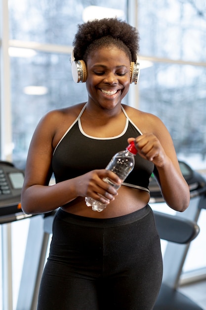 Smiley femme hydratante après l'entraînement