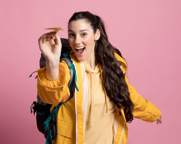 Smiley femme jouant avec un avion en papier