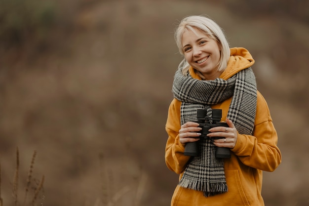 Smiley femme avec des jumelles