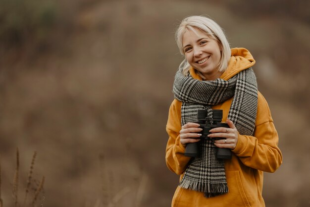 Smiley femme avec des jumelles