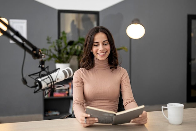 Smiley femme avec microphone dans un studio de radio