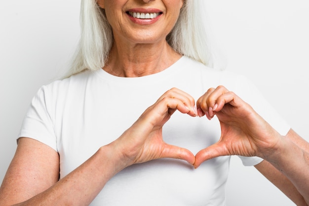 Smiley femme montrant le coeur avec les mains