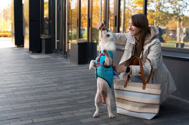 Smiley femme nourrissant chien plein coup