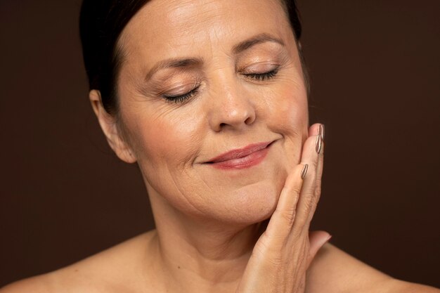 Smiley femme plus âgée posant avec du maquillage sur