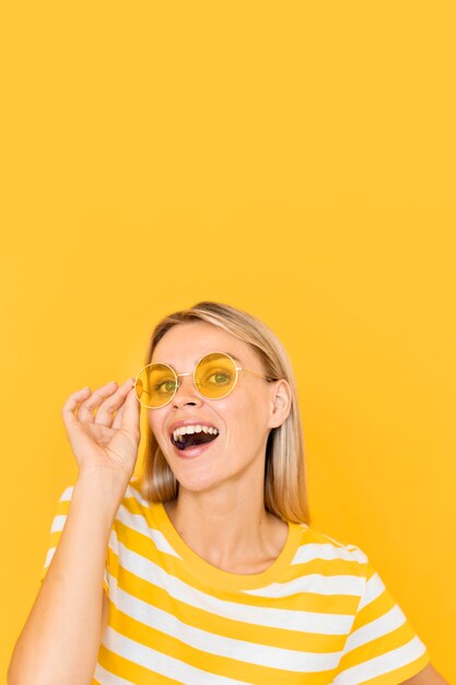 Smiley femme portant des lunettes jaunes