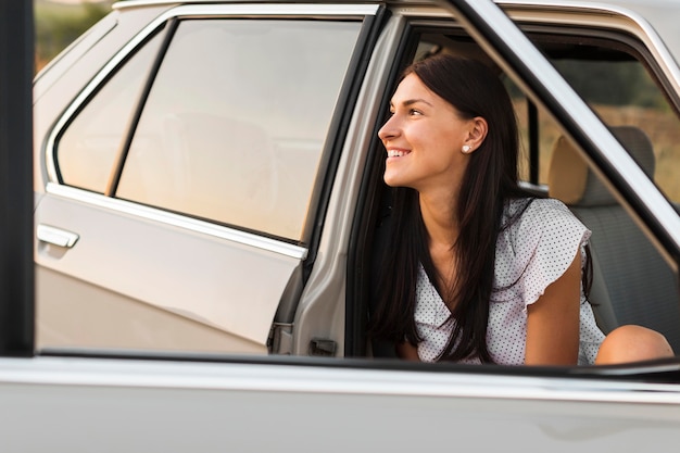 Smiley femme posant dans la voiture