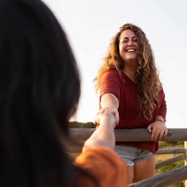 Smiley femme posant à l'extérieur avec un ami