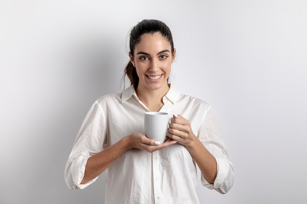 Smiley femme posant avec une tasse