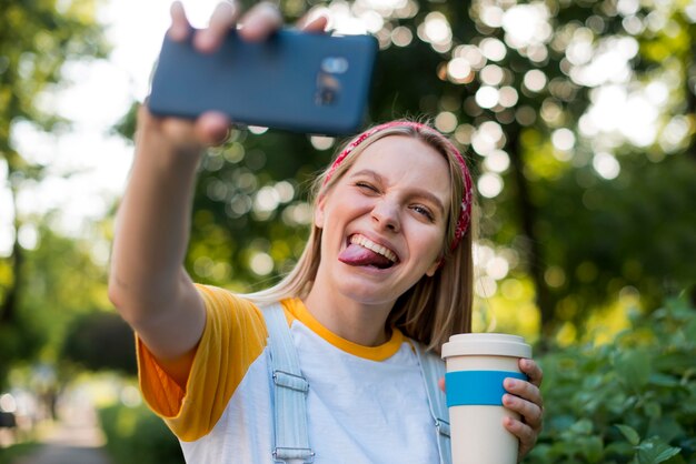 Smiley femme prenant selfie à l'extérieur