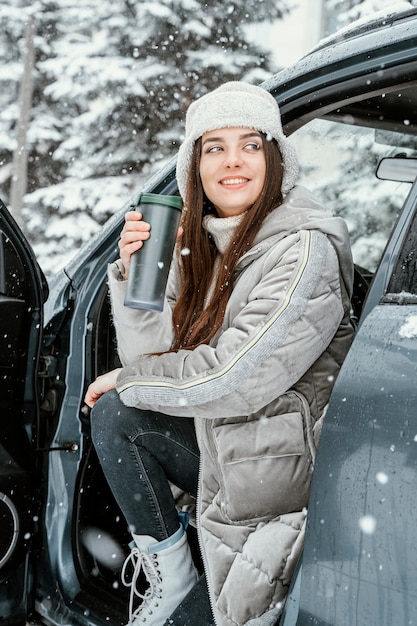 Smiley femme profitant de la neige lors d'un road trip