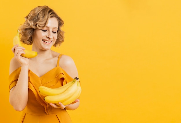 Smiley femme regardant des bananes