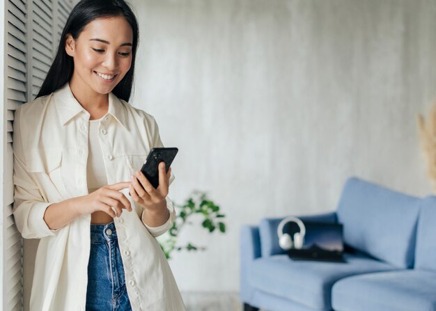 Smiley femme regardant le téléphone avec espace copie