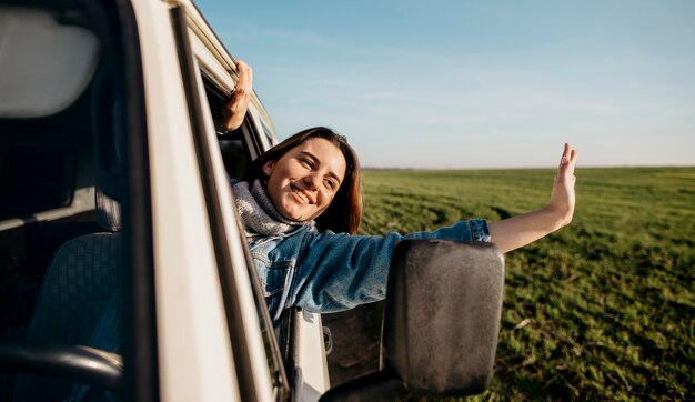 Smiley femme restant avec sa tête hors d'une camionnette