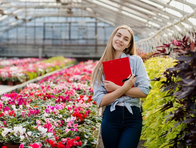 Smiley femme en serre avec presse-papiers