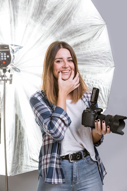 Photo gratuite smiley femme tenant un appareil photo professionnel