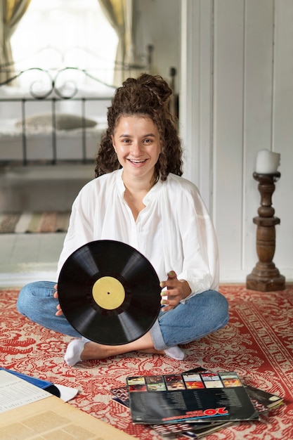 Smiley femme tenant un disque vinyle vue de face