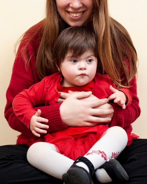 Smiley femme tenant un enfant atteint du syndrome de Down