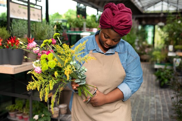 Smiley femme tenant des fleurs vue de face