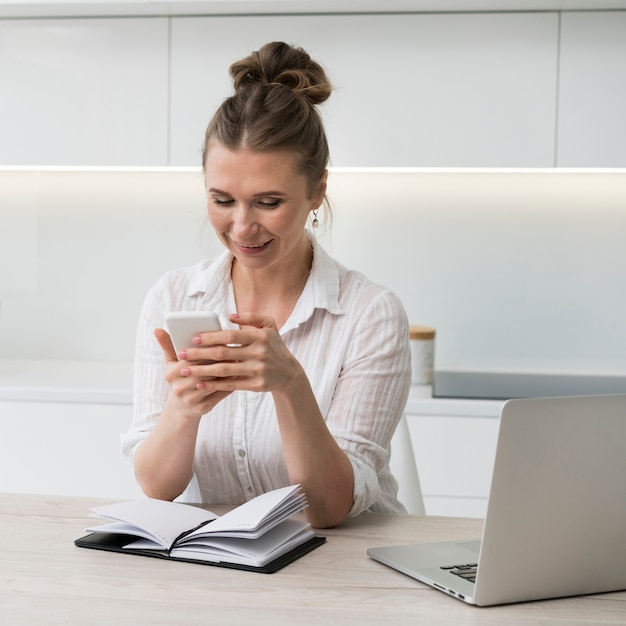 Smiley femme tenant un smartphone