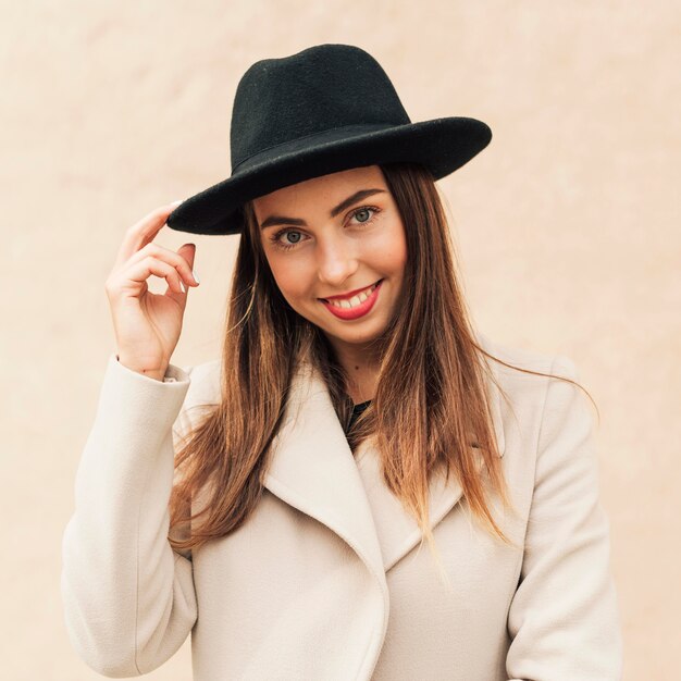 Smiley femme tenant son chapeau