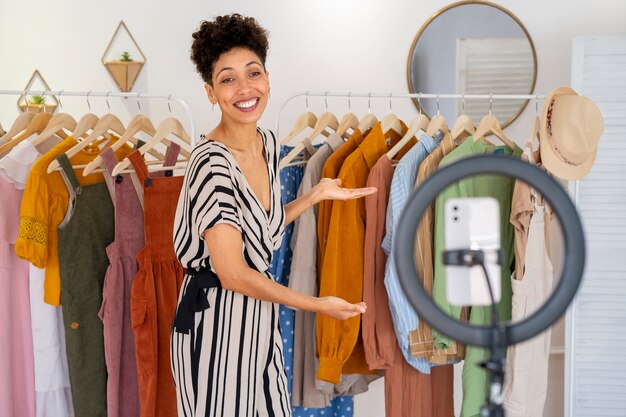 Smiley femme vendant des vêtements vue de côté