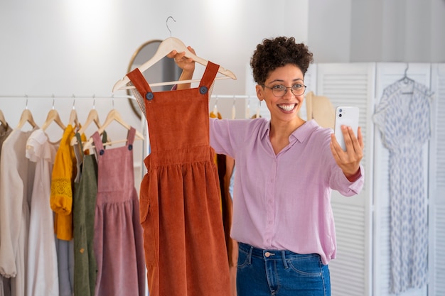 Smiley femme vendant des vêtements vue de face