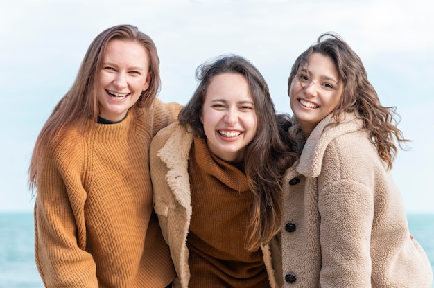 Smiley femmes posant ensemble au bord de la mer