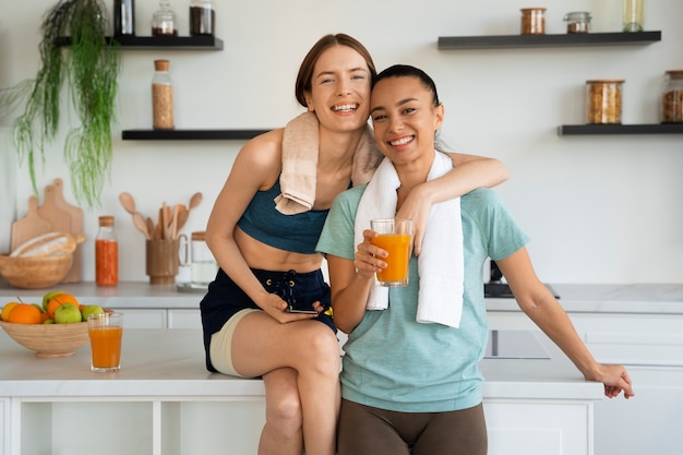 Photo gratuite smiley femmes en vue de face de cuisine