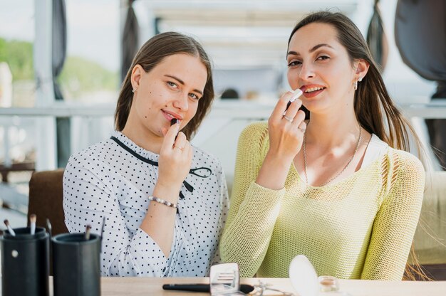 Photo gratuite smiley fille à tir moyen avec des produits de maquillage