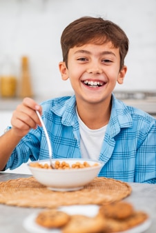 Smiley garçon prenant son petit-déjeuner
