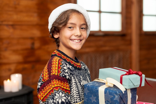 Photo gratuite smiley garçon à tir moyen avec des cadeaux