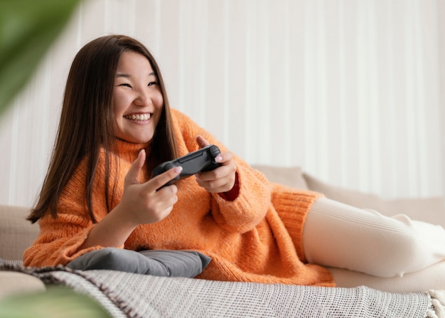 Smiley girl jouant au jeu vidéo avec contrôleur