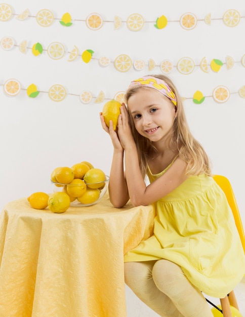 Smiley girl posant avec un citron