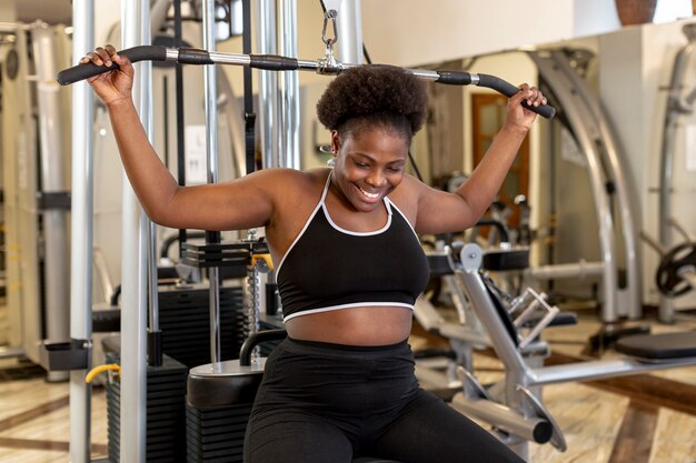 Smiley grand angle femme travaillant au gymnase