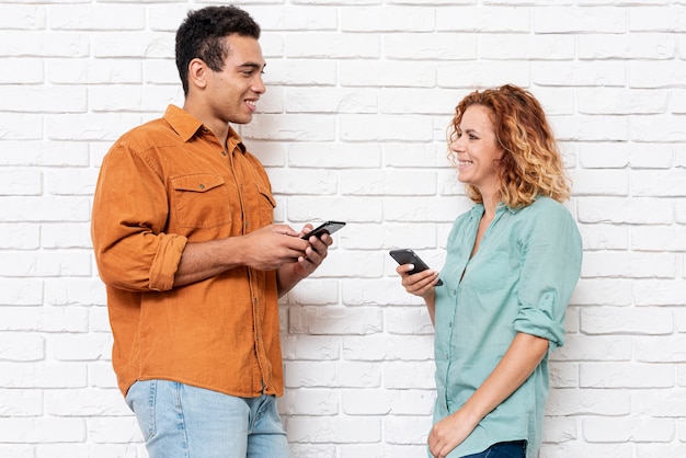 Smiley homme et femme avec téléphones